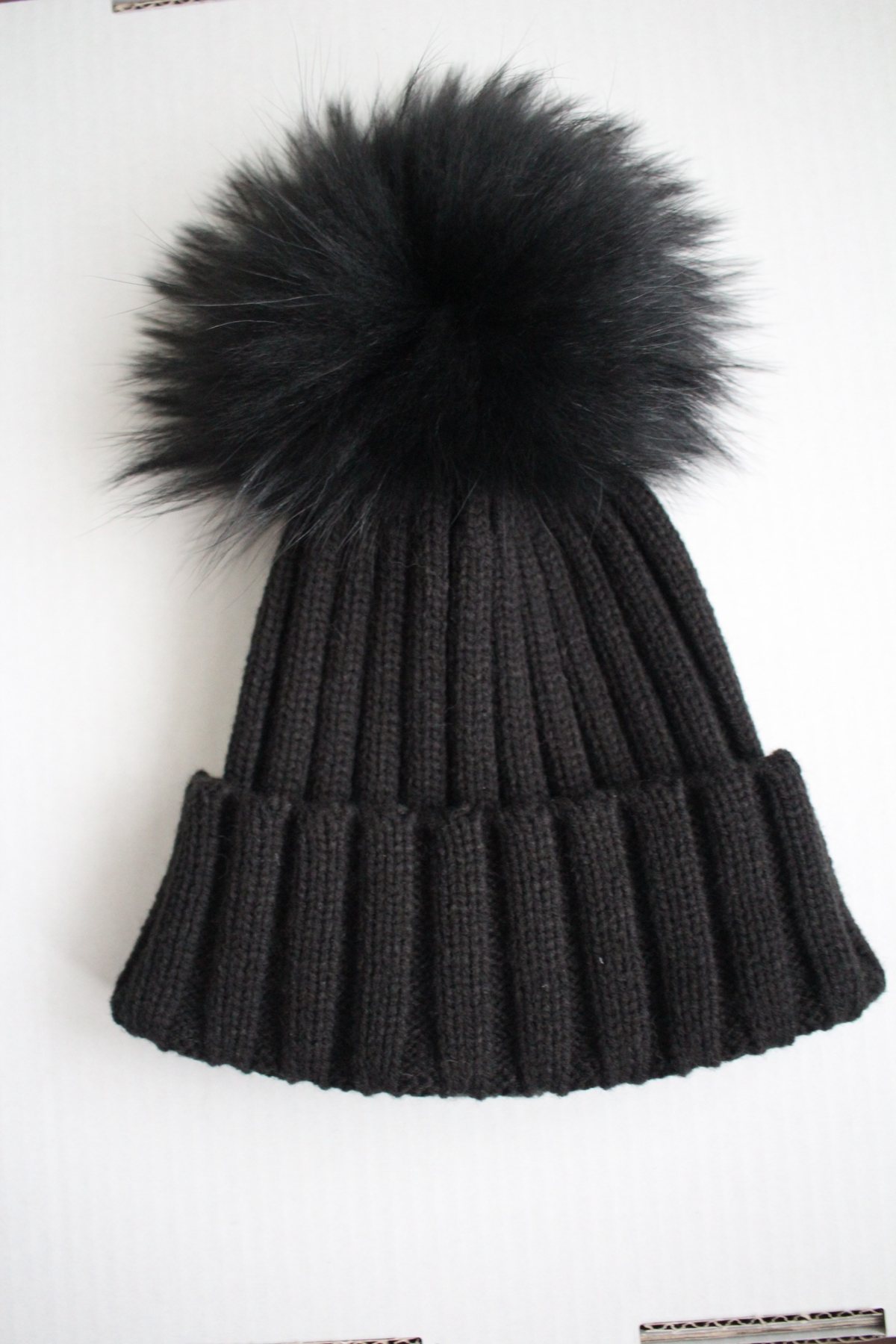 Black pom beanie flat lay