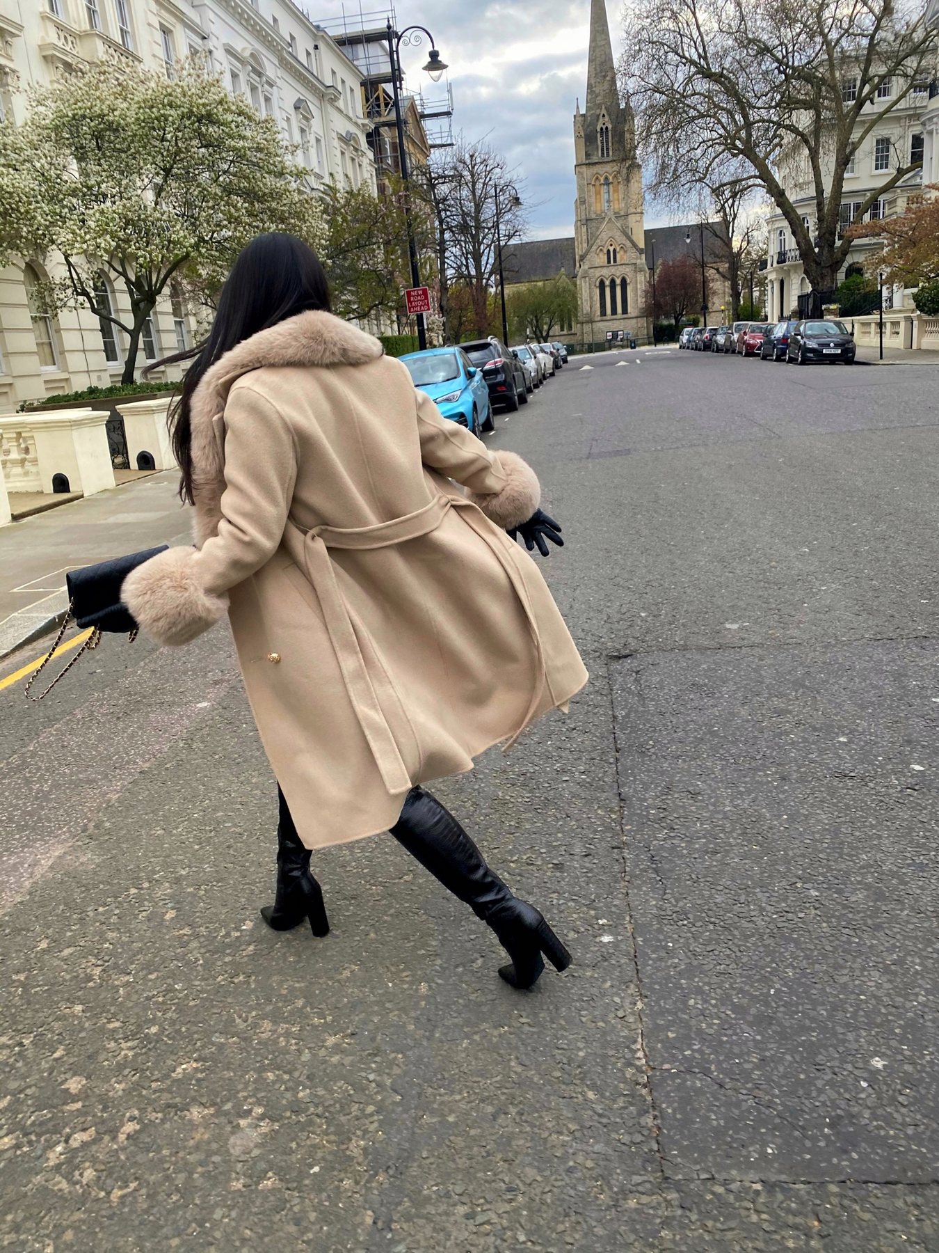 Woman in camel coat on the street