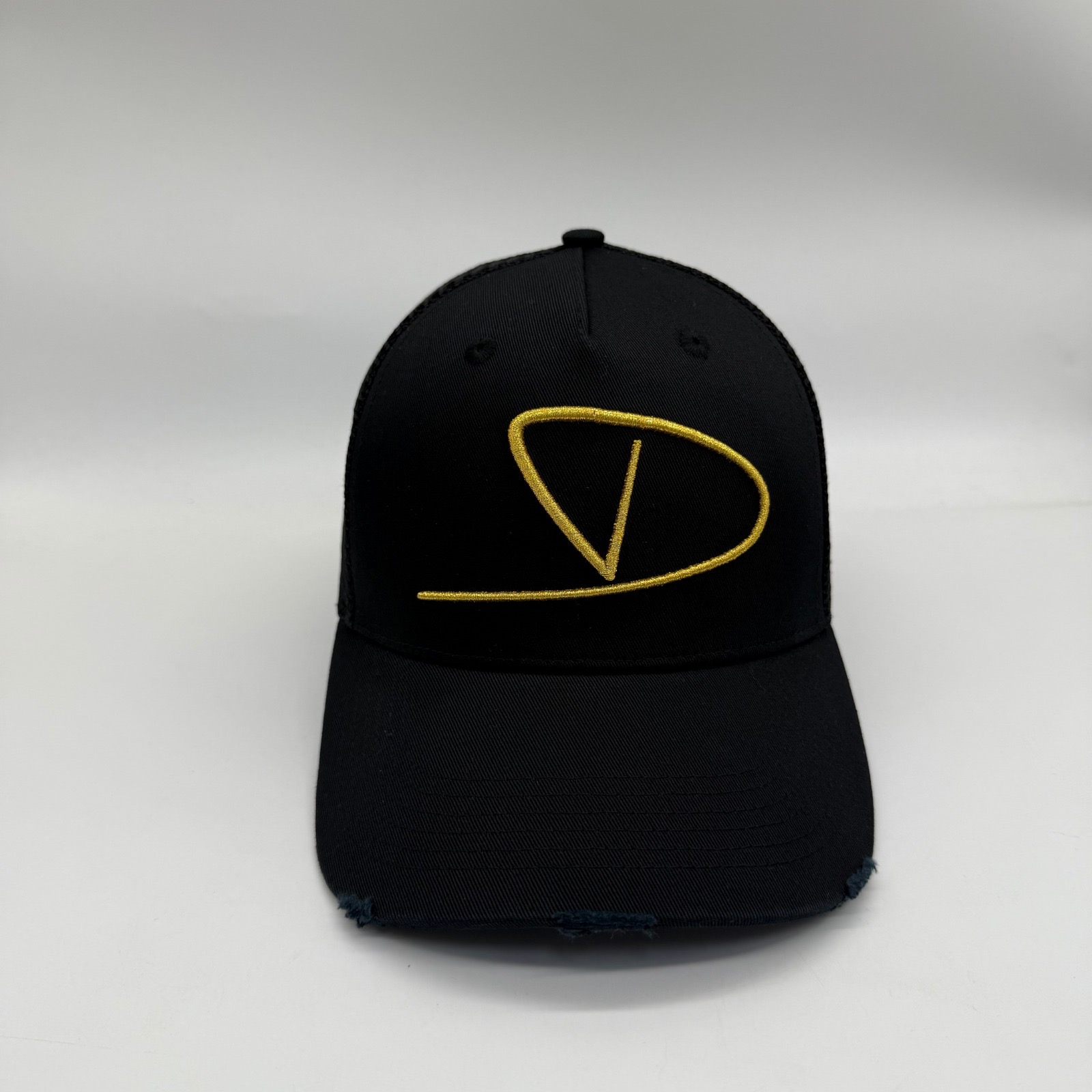 Matte noir Dinero trucker cap front with gold monogram
